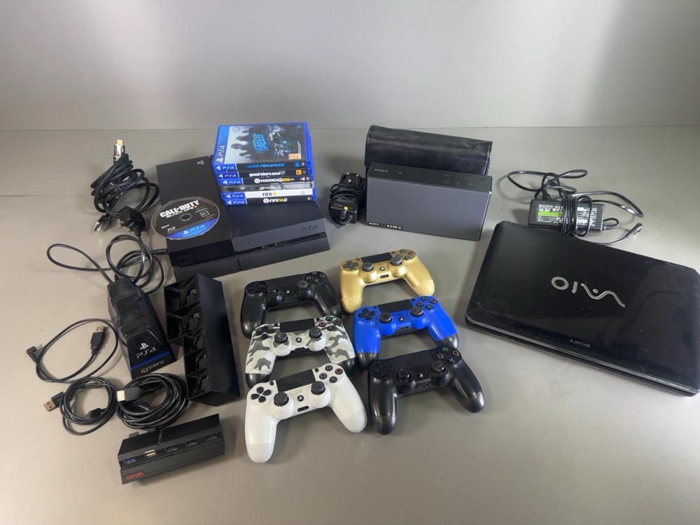 Sony PlayStation 4 console with controllers, games, a VAIO laptop and accessories